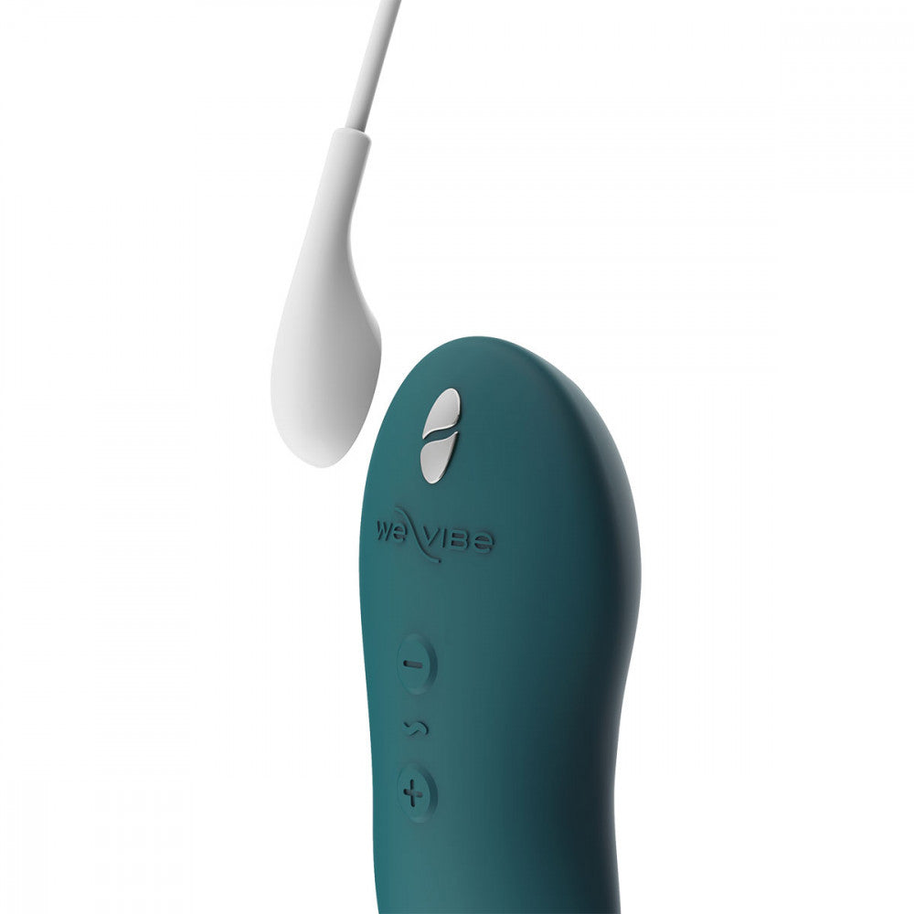 showing the teal green silicone sex toy where the white charging cord magnetically connects to the metal points