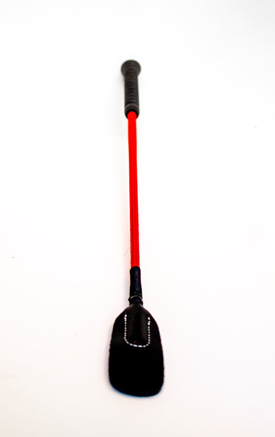 Closeup of black bdsm crop with red shaft and leather-look, thin and rounded tip crop