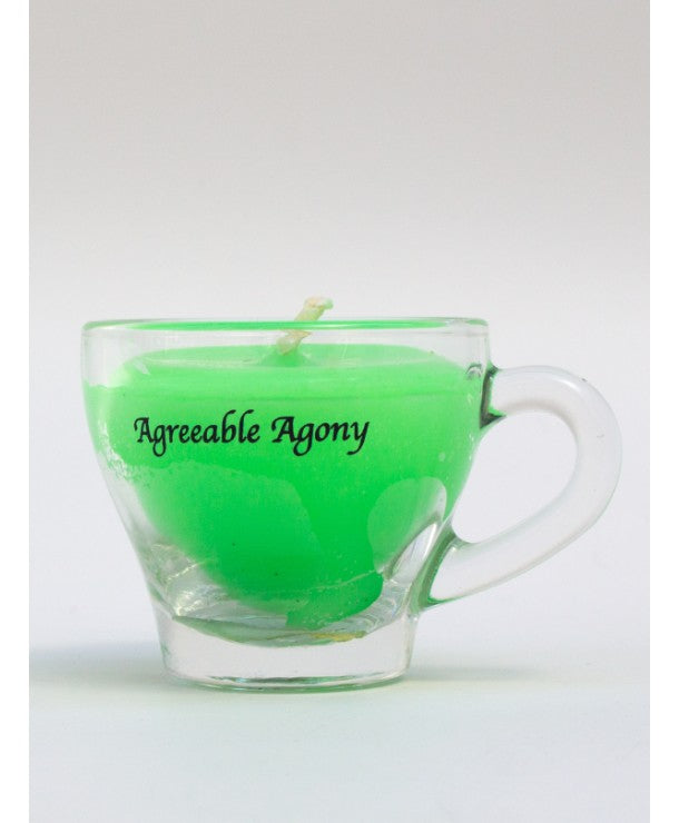 mini espresso glass cup with neon uv reactive candle inside for kinky wax play. sticker says agreeable agony